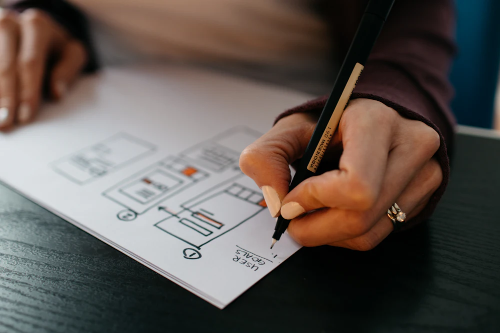 Designer sketching mobile app user interface wireframes